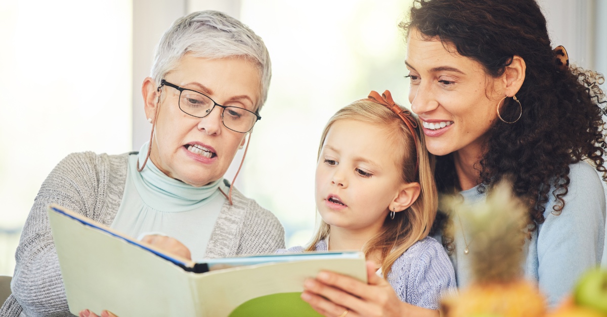 A grandmother reading to her granddaughter.